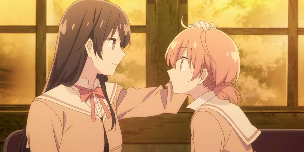 Image features a visual from Bloom Into You: (From left to right) Touko Nanami (long, black hair) is patting Yuu Koito (peach-pink hair in pigtails)'s head